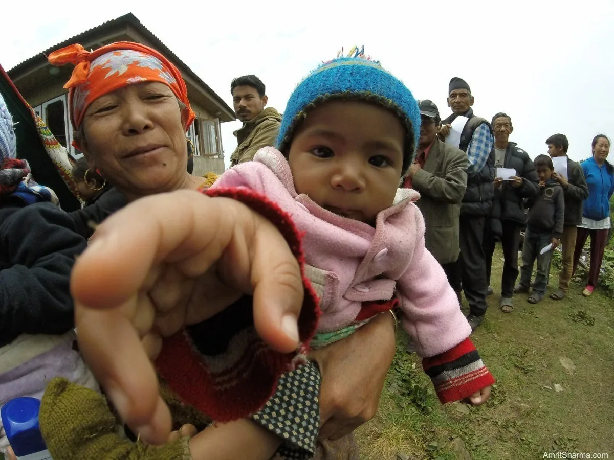 CAPTION THIS. // Baby intrigued by my GoPro while her grandma waits in line for a Health Clinic run by an Indian Hospital, FORTIS, in Shermathang in Sindupalchowk.