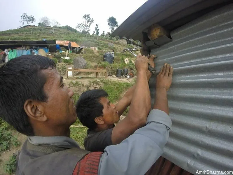 Building sheds out of rubble and roofs of collapsed houses